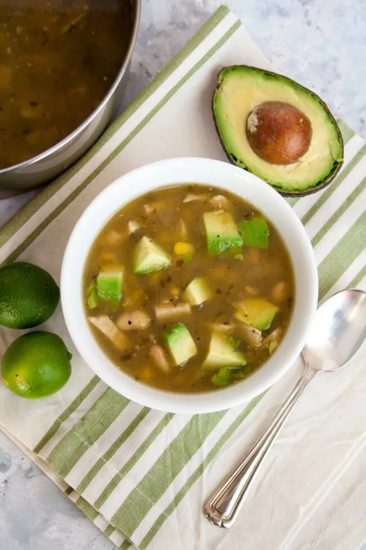 A small bowl of 4-ingredient vegan chili verde next to half of an avocado.