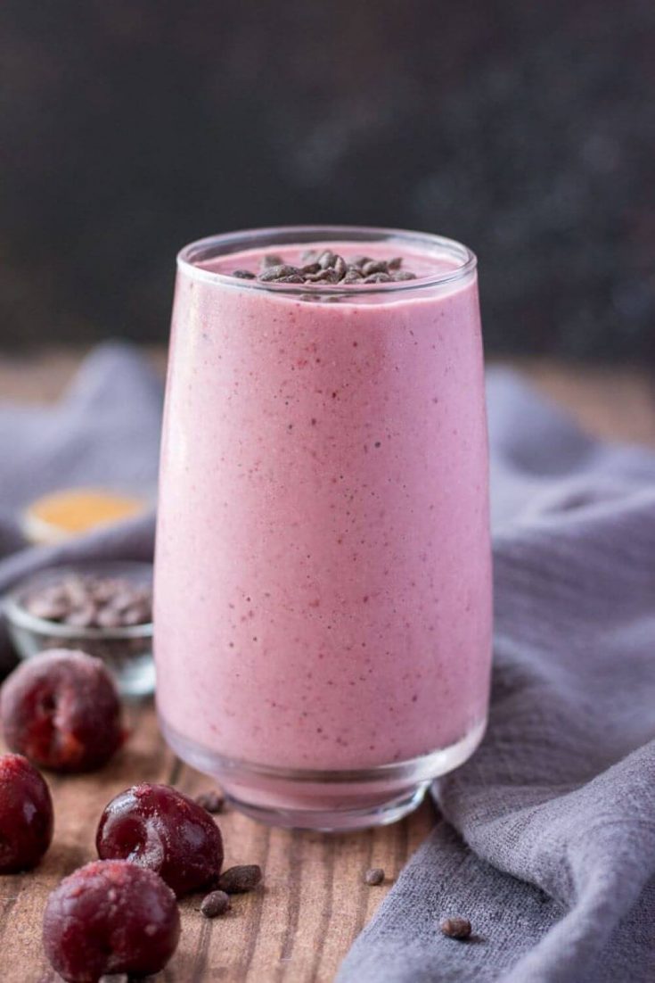 A tall glass of cherry banana breakfast smoothie.