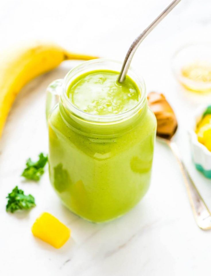 A mason jar filled with kale pineapple smoothie.