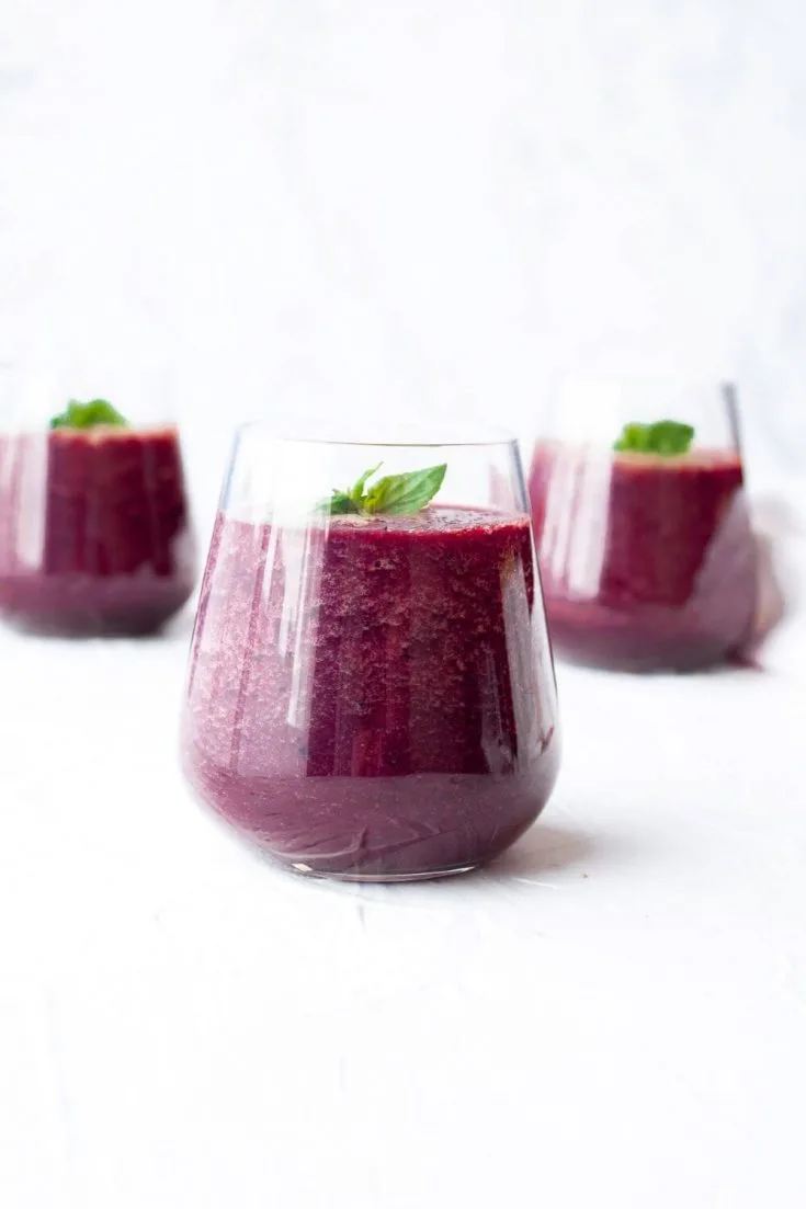 Three short glasses of spinach beet smoothie.