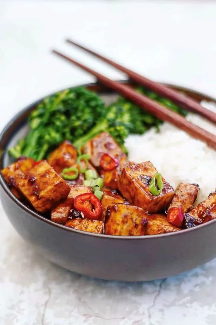 A large bowl of Asian BBQ tofu bowl served with rice and broccoli.