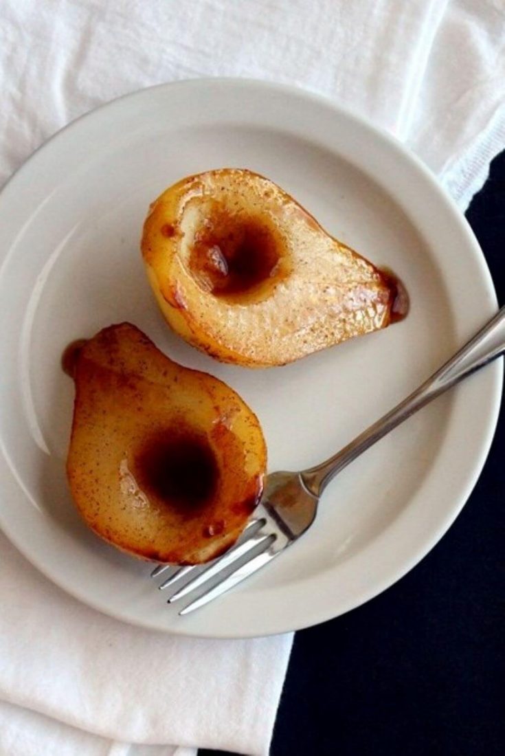 Two halves of a delicious baked pear on a plate.