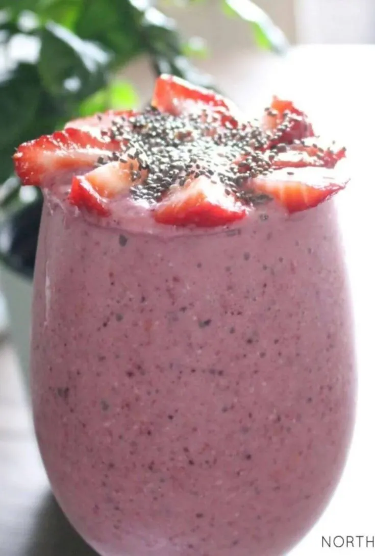 A close-up glass of energy boosting oatmeal berry breakfast smoothie.
