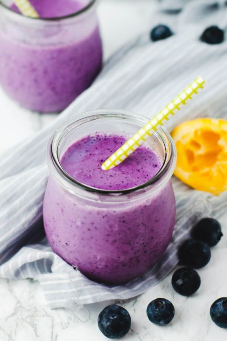 A small glass of lemon blueberry smoothie with a straw in it.