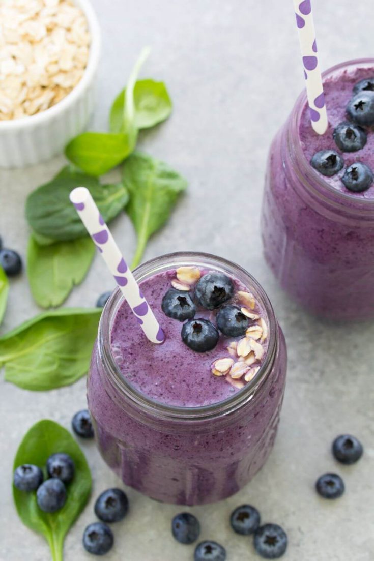 A bird's eye view of a mason jar filled with a spinach blueberry breakfast smoothie.