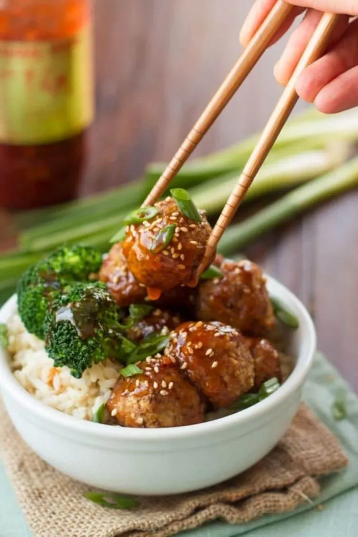 A bowl of saucy ginger glazed tofu meatballs served with broccoli and rice.