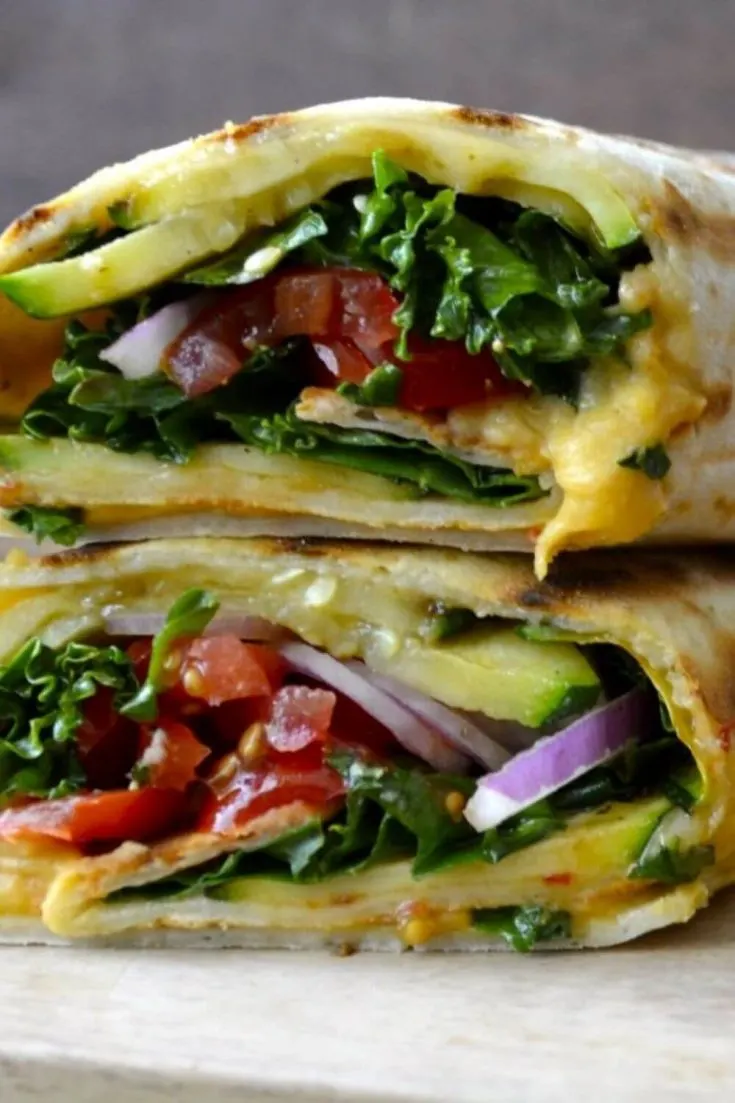 A closeup of two stack grilled zucchini hummus wraps.