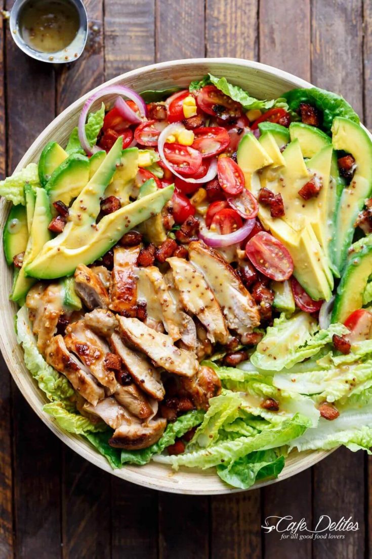 A large bowl of honey mustard chicken salad with bacon and avocado.