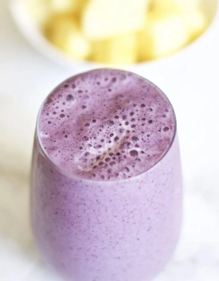 A full glass of delicious pineapple blueberry smoothie.