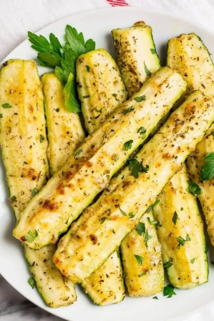A large plate of roasted zucchini spears.