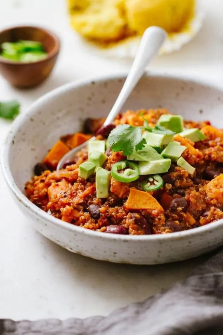 A delicious bowl of sweet potato and quinoa chili with a spoon.