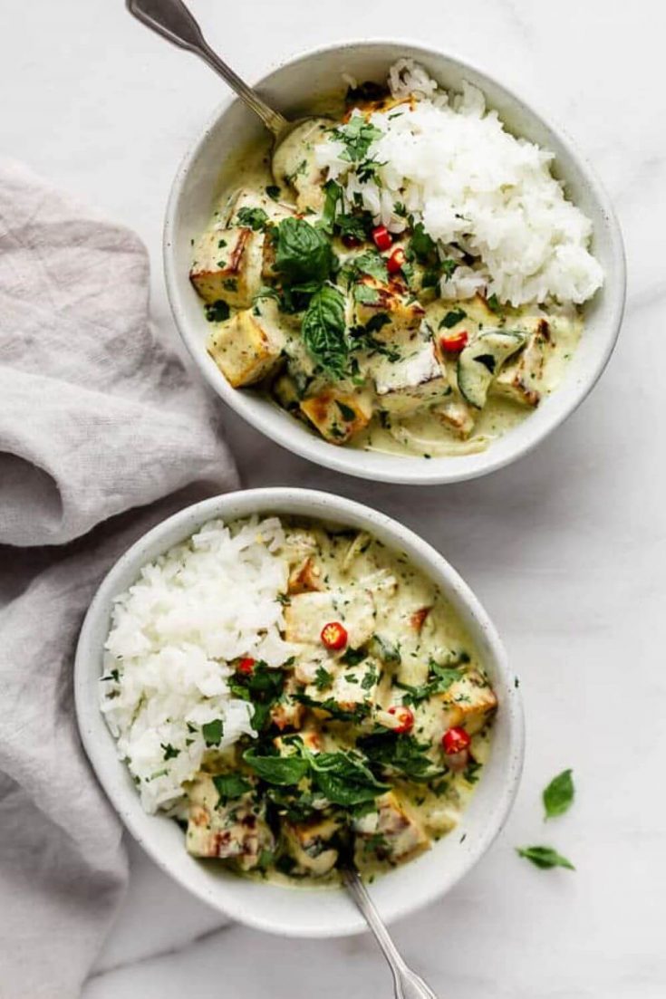 Two bowls of Thai green curry tofu over rice.