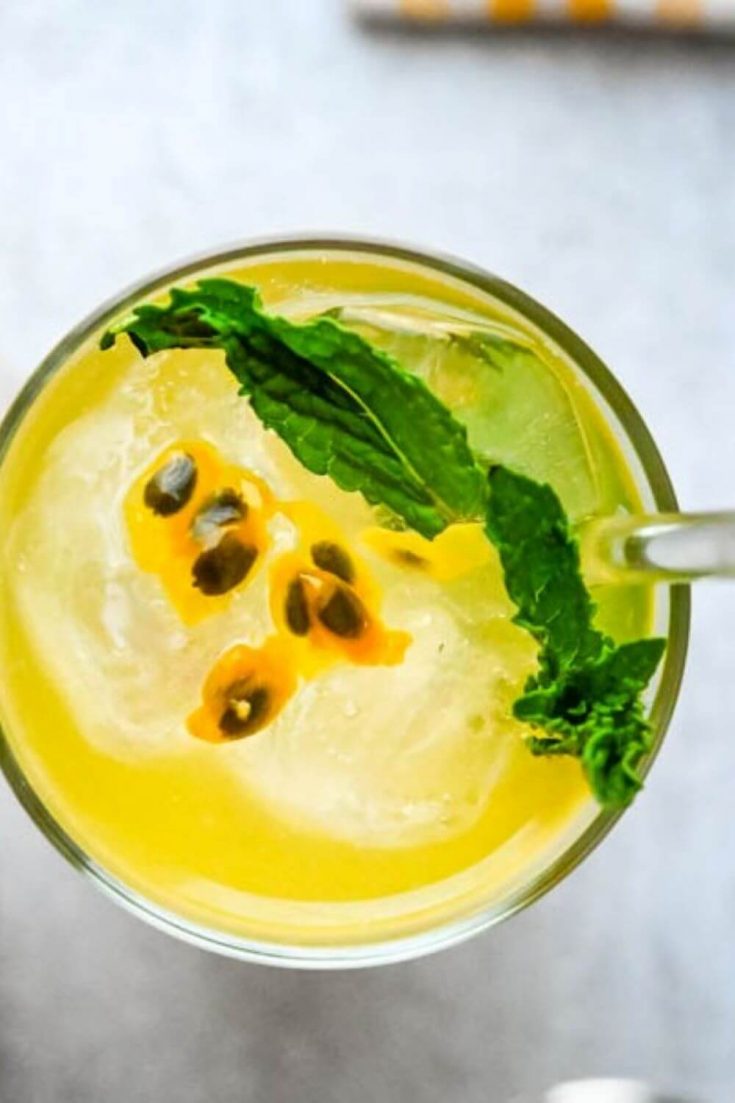 An overhead view of a tropical bubbly passion fruit mojito in a glass.
