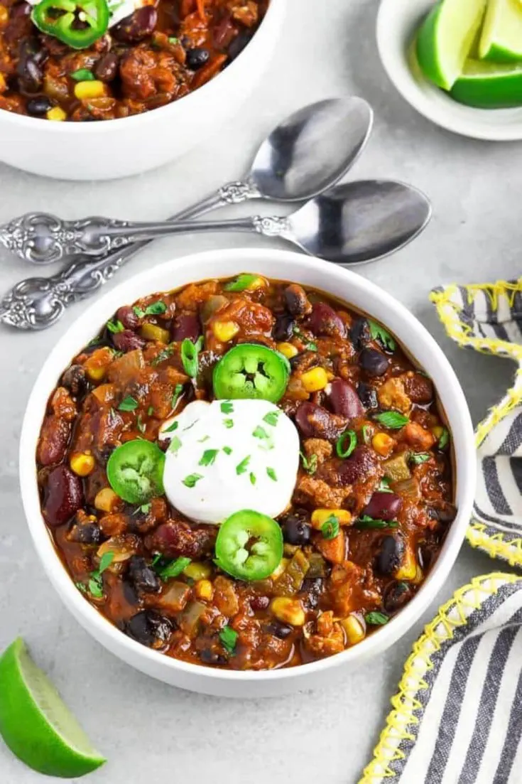 A heaping bowl of ultimate vegan chili topped with sour cream and jalapenos.