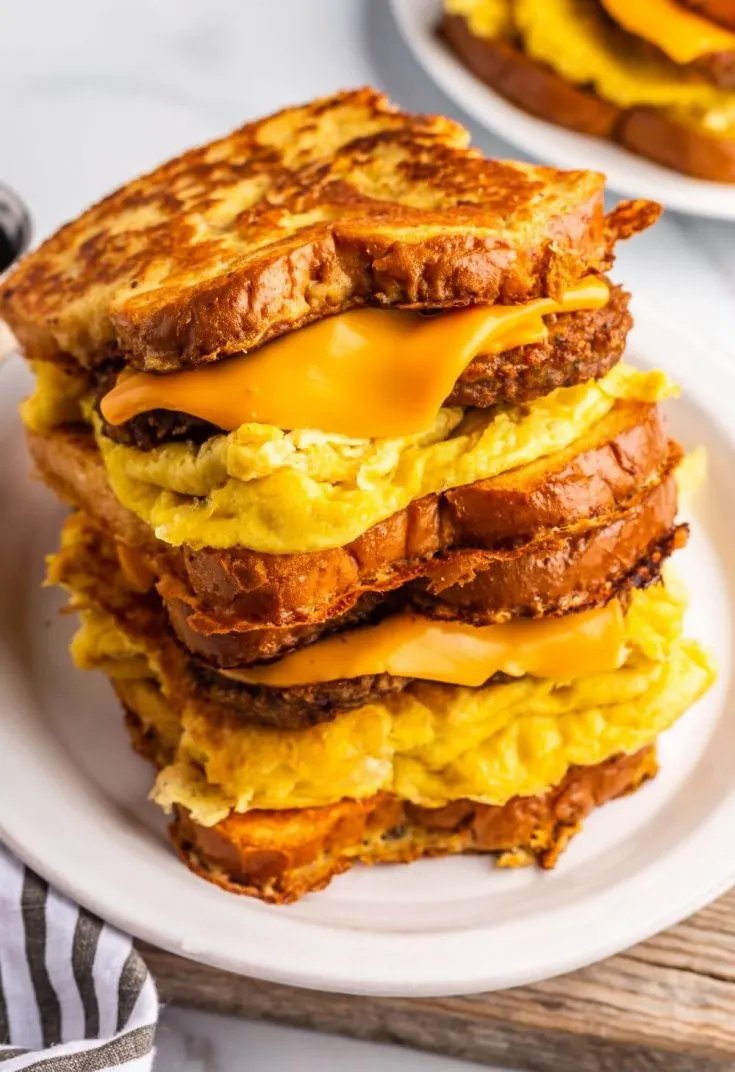 Two vegan french toast breakfast sandwiches stacked on top of each other.