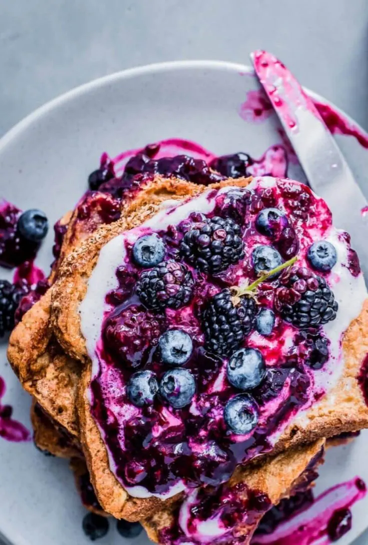 A colorful plate of vegan french toast topped with berry compote.