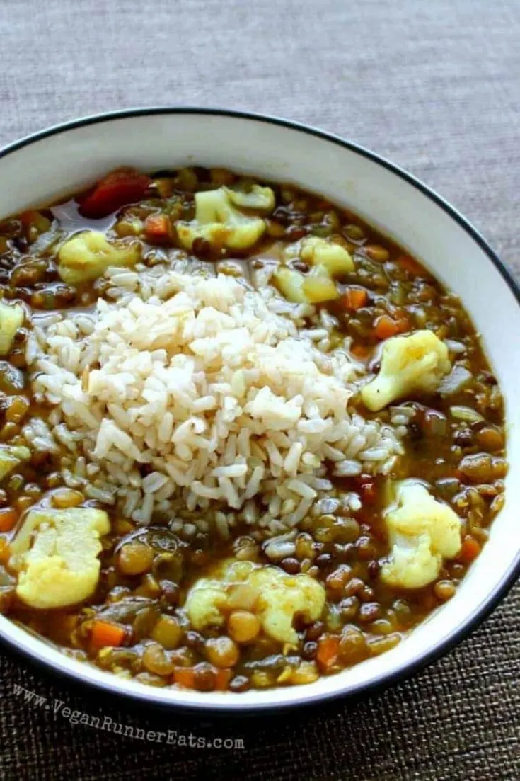 A large bowl of vegan lentil soup with cauliflower and rice.