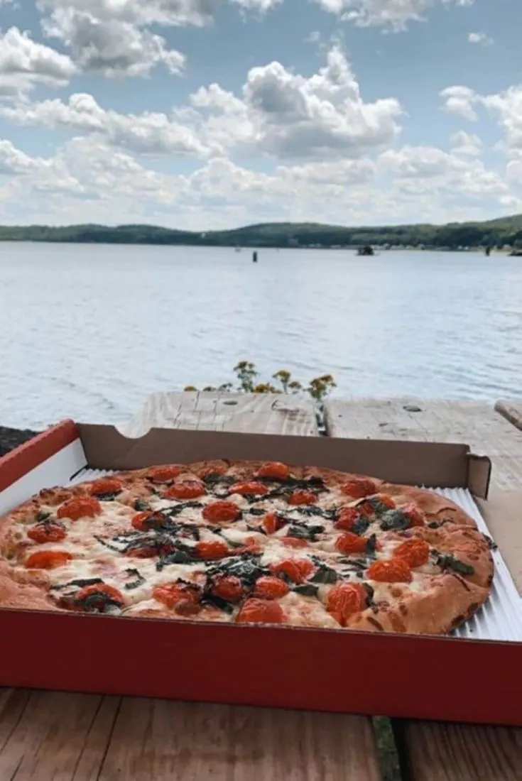 A large Margherita pizza from Aubree's with Lake Superior in the background.