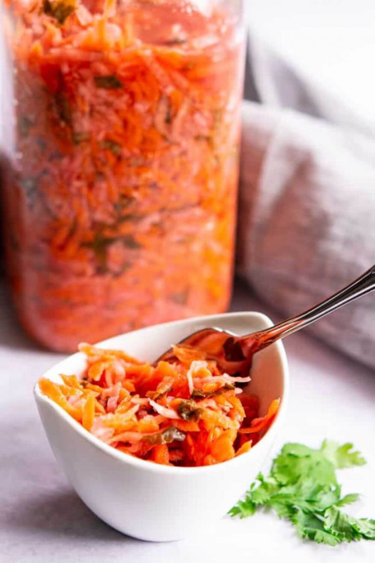 A dish and jar of fermented radish and carrot slaw.